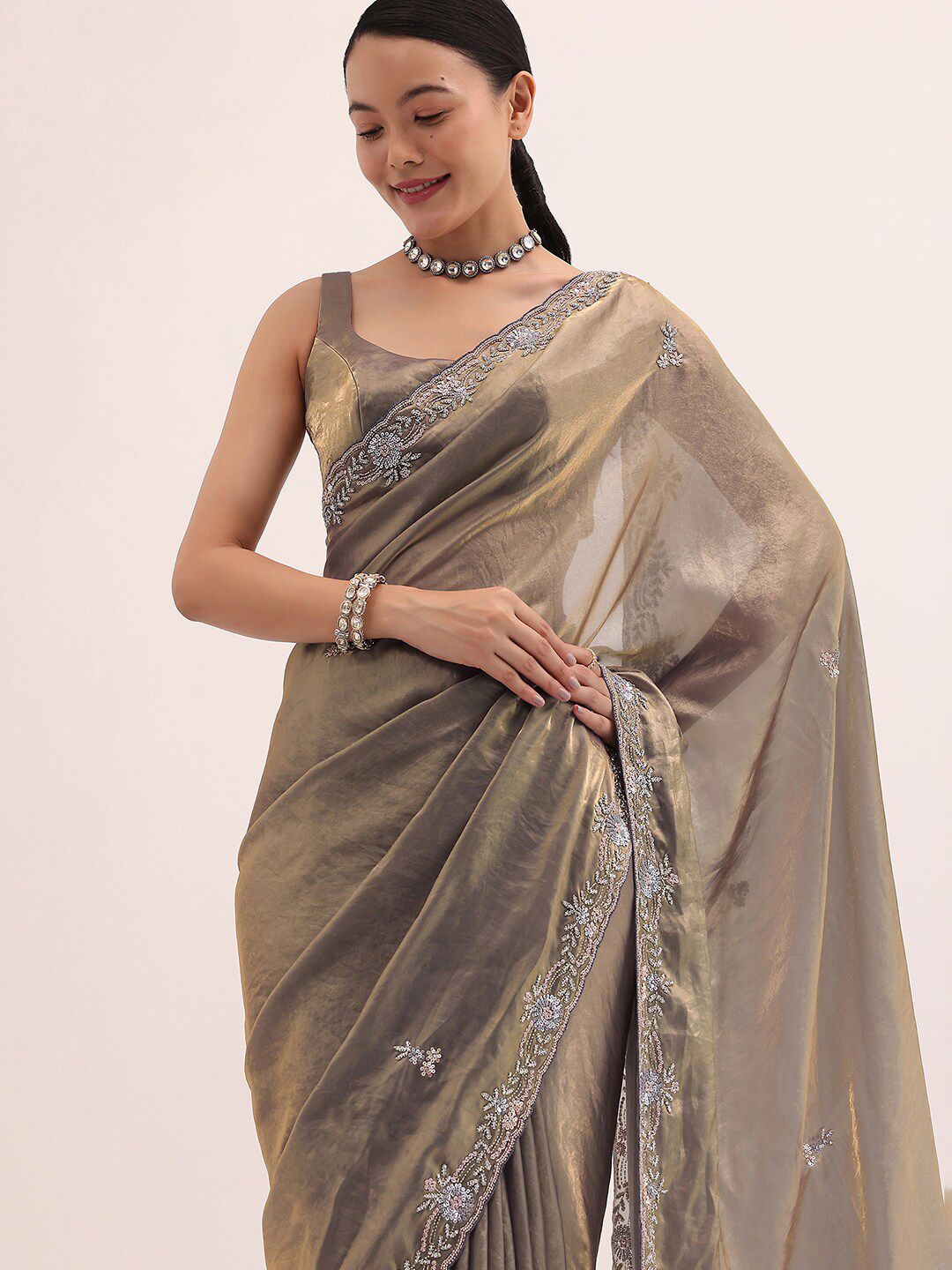 a7e7f4ad-be32-44ba-8fb8-d0a0517c0b8d1715260483160GreyGoldSatinSareeInSequinsWithUnstitchedBlouse1.jpg KALKI Fashion Floral Embroidered Satin Saree - Image 1